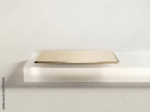 Gold credit card resting on a minimalist clear acrylic display platform for luxury finance.