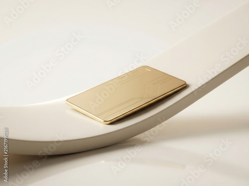 Gold credit card resting on a curved white surface for luxury banking and finance concepts.