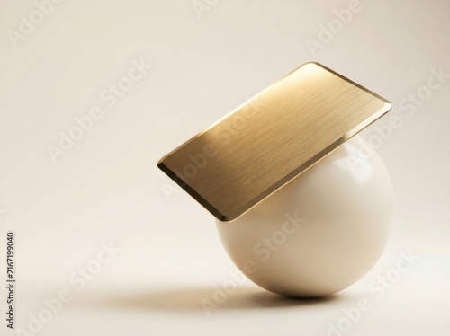 Golden credit card balancing on white sphere against minimalist background for luxury finance concept