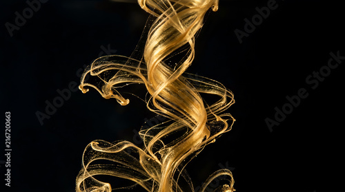 Gold Liquid Ink Tornado Motion Flowing in Water Isolated on Black Backdrop
