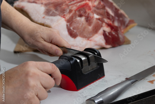 Fotografía Close-up of raw pork leg being deboned in a home kitchen setting