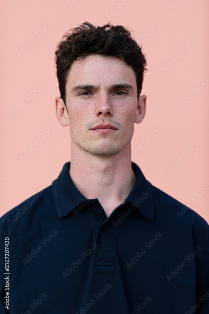 Fototapeta premium Vertical young male portrait with pink background for poster and profile banner design