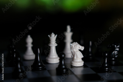 Obraz na płótnie Chess piece strategy with white knight facing black opponent on checkered board