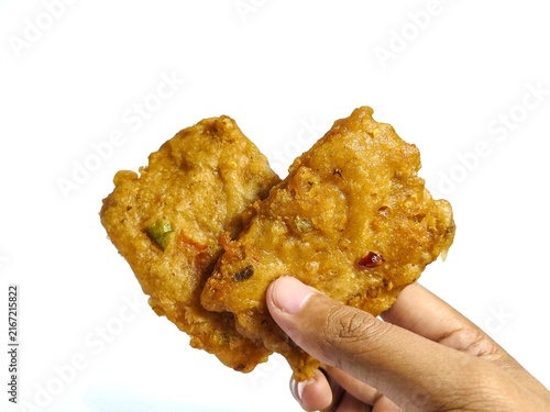 Картината върху платно Hand holding crispy fried battered tempeh isolated on white background