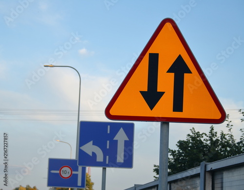 Photography Polish Yellow traffic sign with double downward arrows indicating lane merge or