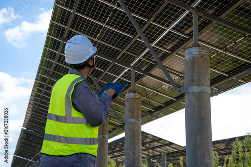 Worker Inspects Solar Panel System With Digital Tablet