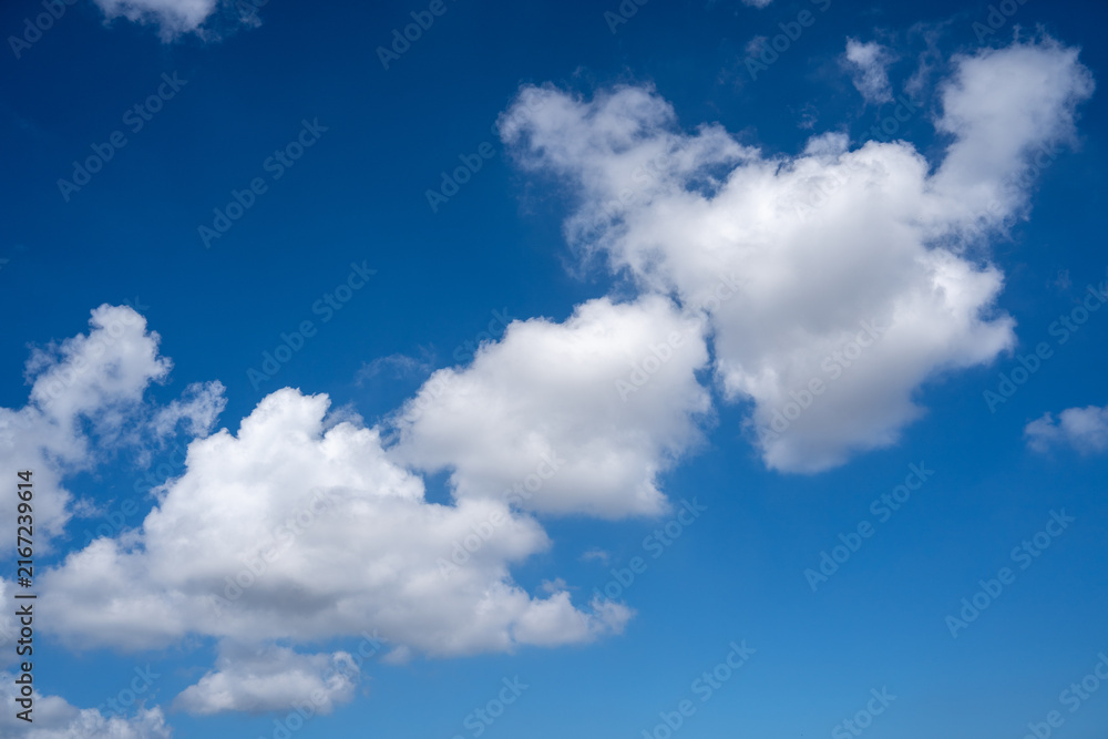 Fototapeta premium Bright White Cumulus Clouds Against Deep Blue Sky