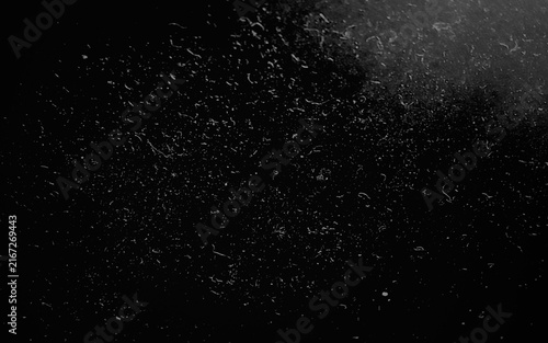 A dark grunge film grain overlay texture featuring scattered dust particles and scratches against a deep black background for vintage photography effects.