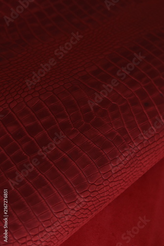Close-up view of red crocodile embossed leather texture. Luxury material detail with elegant pattern, rich color, and premium fashion design aesthetic, suitable for backgrounds and product concepts.
