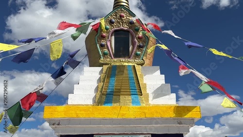 Russia - August 12, 2025: Tibetan stupa with colorful prayer flags fluttering in the wind under a clear blue sky, highlighting intricate architectural details