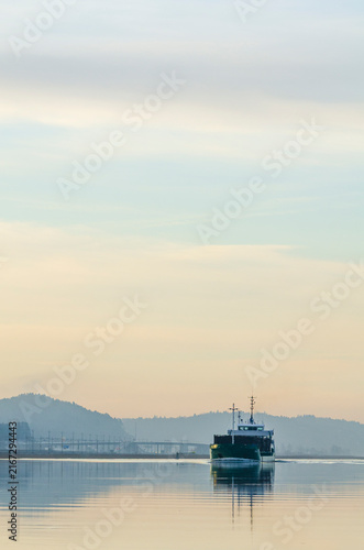 Freight ship moves along river Gota Alv in Sweden during early morning hours