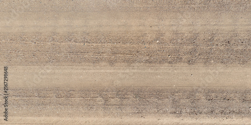 view from above on texture of gravel road among grass field