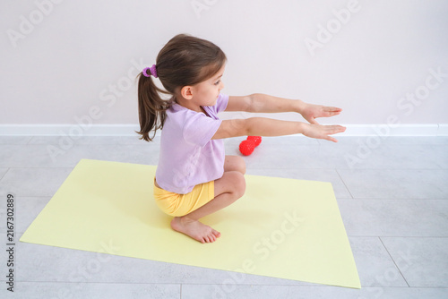 Fotografía Young Girl Squats On Yoga Mat With Arms Stretched Forward During Home Exercise P