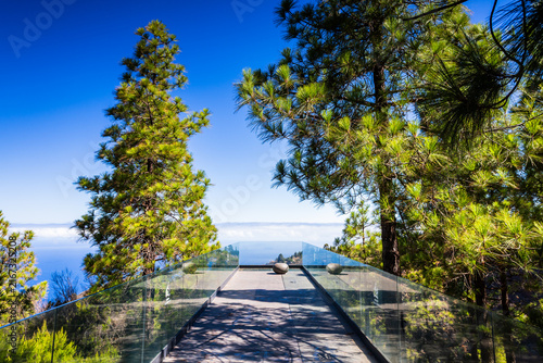 Glass-walled viewpoint runway among pine trees at Mirador Izcagua in Puntagorda