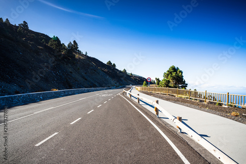 Paved mountain highway with wooden guardrails in La Palma