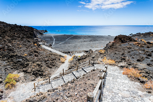 Cobblestone stairs leading to black sand cove and blue ocean in La Palma