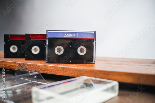 Vintage cassette tapes and film camera on wooden shelf