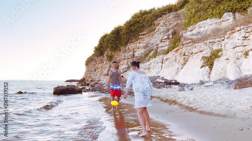 Mother and teenage son enjoying playful outdoor activity on the shoreline representing positive parenting healthy family values and quality time. High quality FullHD footage