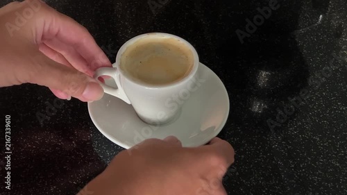 Female hand places a small espresso cup on a saucer, rotates the cup and moves the saucer while creating authentic ceramic sounds. High quality FullHD footage