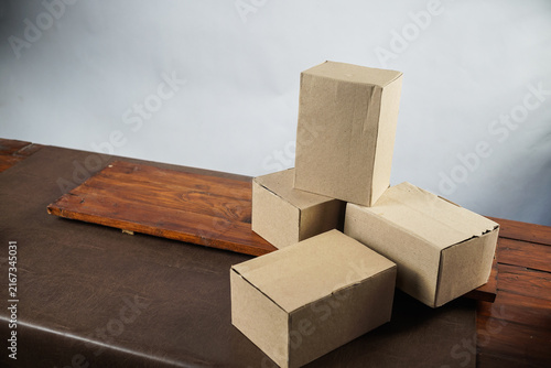 Plain cardboard boxes stacked on wooden board