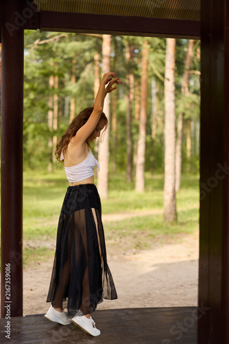 фотографія Vibrant female artistically stretches as sunlight highlights her silhouette