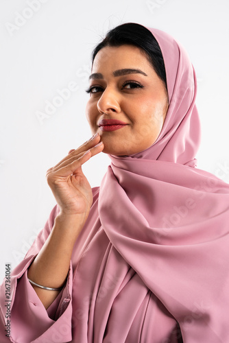 Принти на полотні Beautiful muslim woman wearing pink hijab and abaya gently touching her face