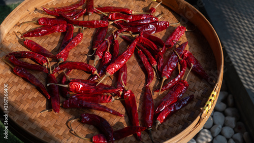 Dried chili peppers on traditional indonesian woven bamboo basket (besek), prepared to make sambal (spicy sauce), chili oil, or other hot dishes