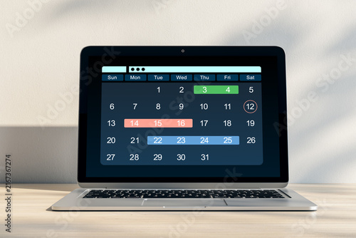 Digital calendar application displayed on a laptop screen for business planni...