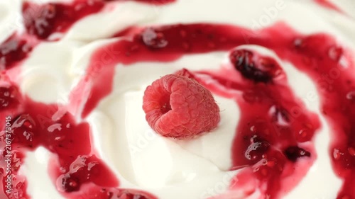 White yogurt with raspberry close up, rotation. Creamy dessert texture, fresh healthy breakfast
