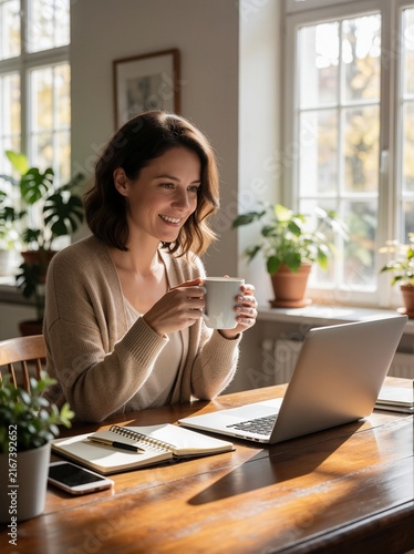 Smiling Woman Working from Home with Laptop and Coffee in Sunny Room