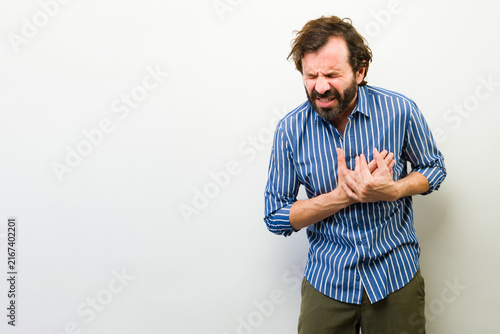 Fotografía Latin man feeling severe chest pain, suffering heart attack or cardiac arrest, e