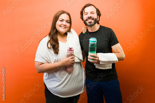 Fotografía Fitness couple smiling after workout, staying hydrated with water bottles, promo