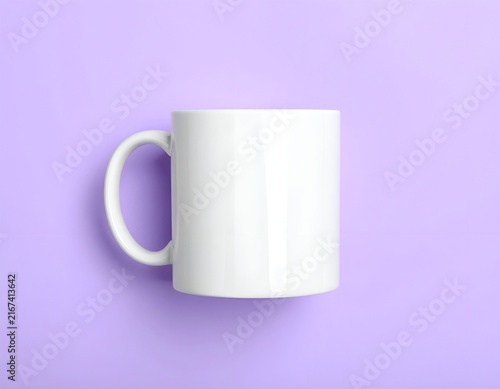 White porcelain mug on purple studio background.