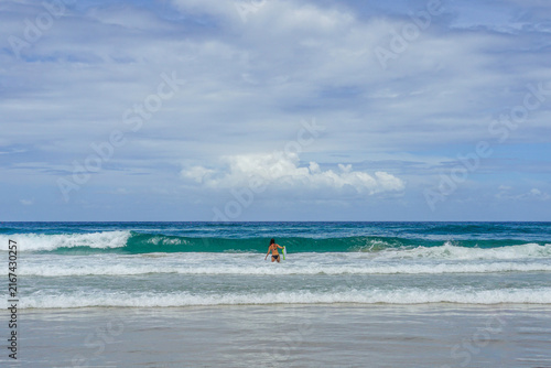 Obraz na płótnie Surfers Paradise Woman entering ocean with bodyboard for surfing