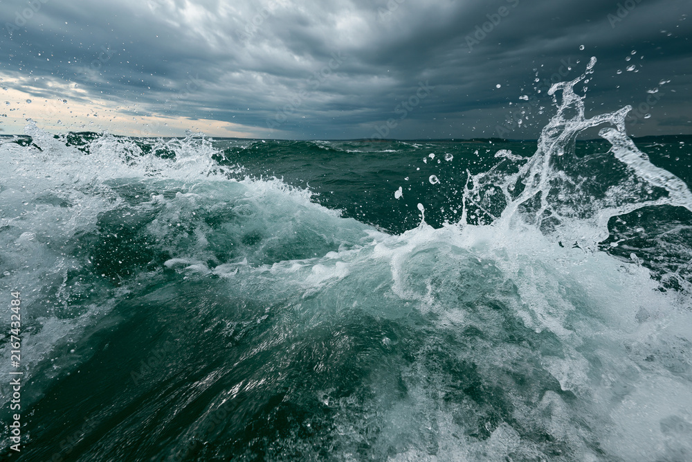 Obraz premium Powerful Ocean Waves Crashing Under a Dramatic Cloudy Sky