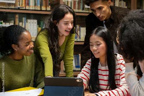 Diverse high school students collaborating and learning together in a university library