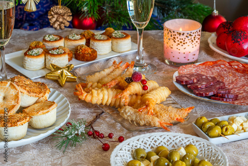 Christmas party, a selection of gourmet snacks and champagne set on a table. Selective focus