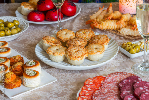 Christmas party, a selection of gourmet snacks and champagne set on a table. Selective focus