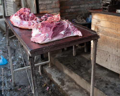 фотографія Two large slabs of meat on a rustic vintage table in a local village of Varanasi
