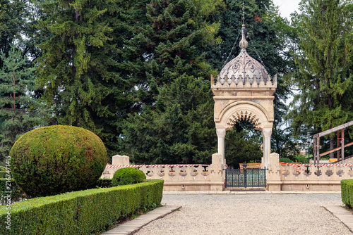 Ornate stone gateway and formal garden at Curtea de Arges Monastery in Arges County, Romania