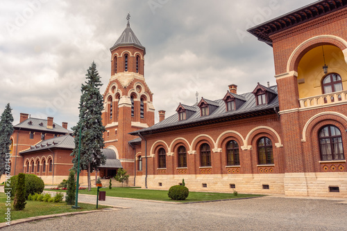 Red brick monastery buildings and bell tower at Curtea de Arges Monastery, Arges County, Romania