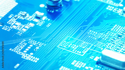 Obraz na plátne Blue electronic circuit board close up with fine pathways, tiny components, and glowing cyan light