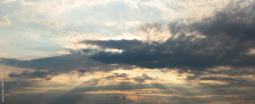 Obraz premium Dramatic sky with sun rays through dark clouds at day's end