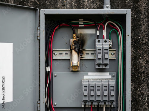 Damaged Electrical Panel Box with Burnt Component and Circuit Breakers for Short Circuit Failure and Maintenance Safety Concept