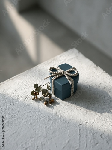 Dark Teal Gift Box with White Rope Bow on Stone