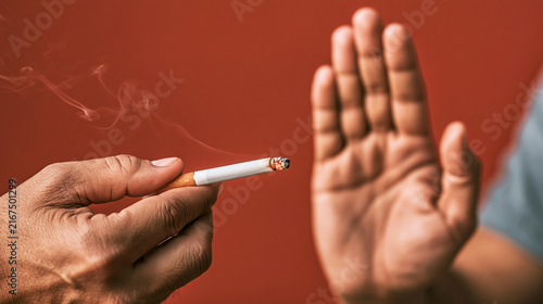 Hand refusing a lit cigarette, symbolizing stopping smoking, health protection, and quitting nicotine addiction