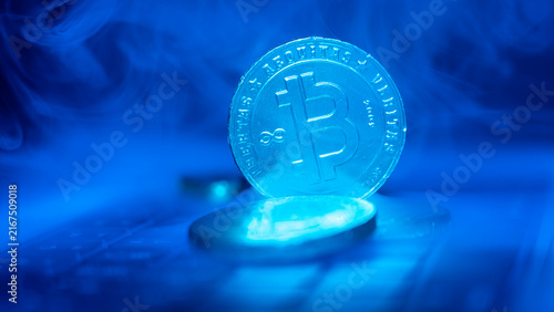 Fotografie Digital currency coin glows under blue light