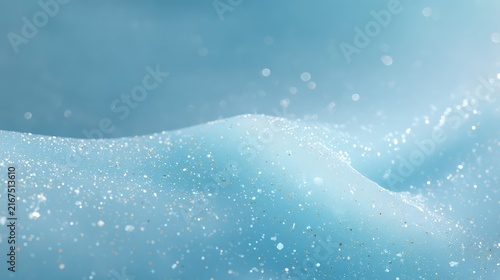 A dreamy abstract background with blue hues and shimmering glitter particles. This luminous scene evokes the beauty of snow and icy winter sparkle.