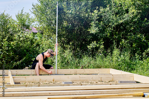 Graduated rod supports surveying work as professional operator maintains vertical position for reliable elevation readings and site measurements.