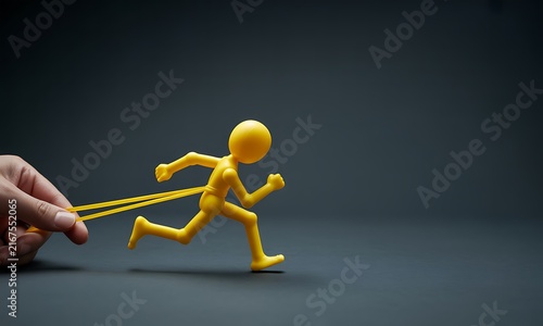 Yellow toy figure running while held back by a rubber band
